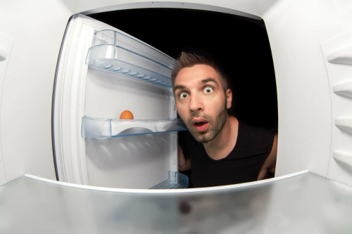 мужчина смотрит в холодильник